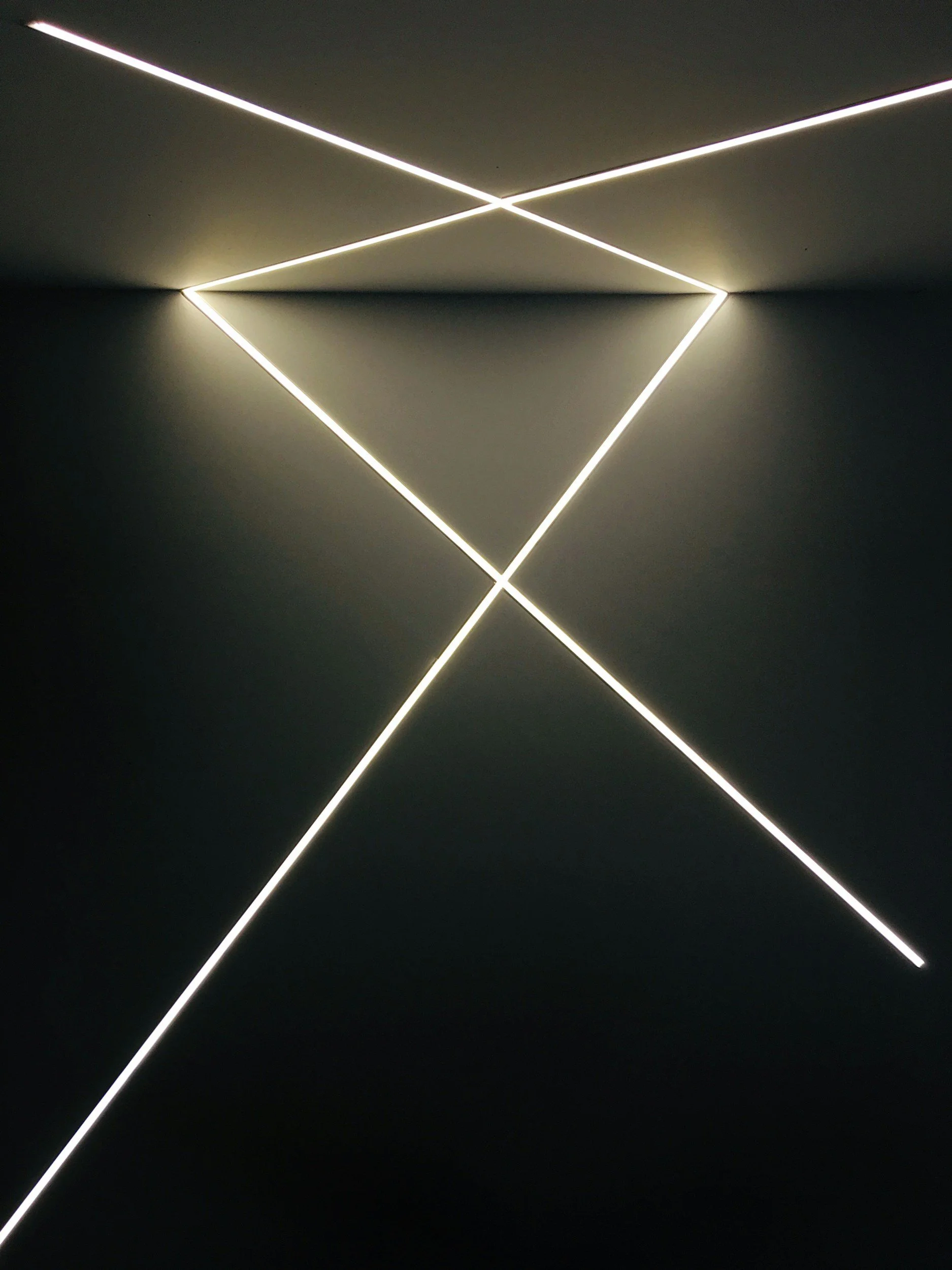 Modern ceiling light fixture with intersecting LED light strips creating geometric shapes.