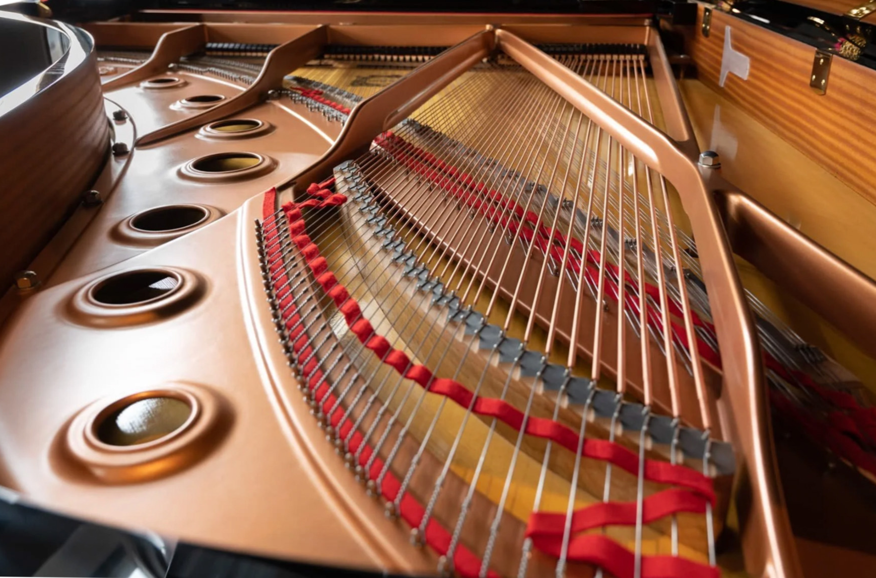 Shot of the piano's plate and strings from the rear view under the lid.