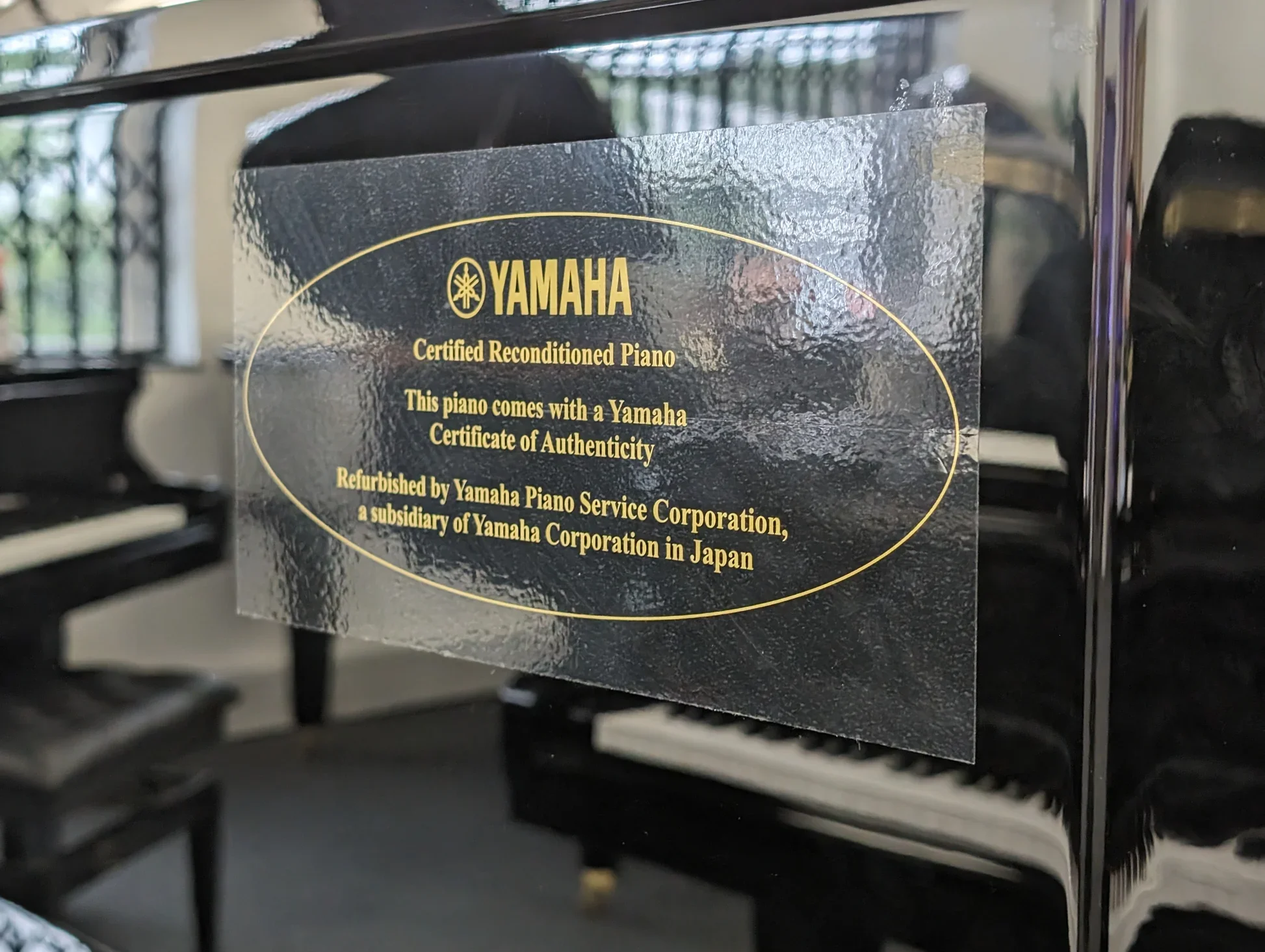 Decal of Yamaha's Certified Reconditioned Piano Program on upright piano panel