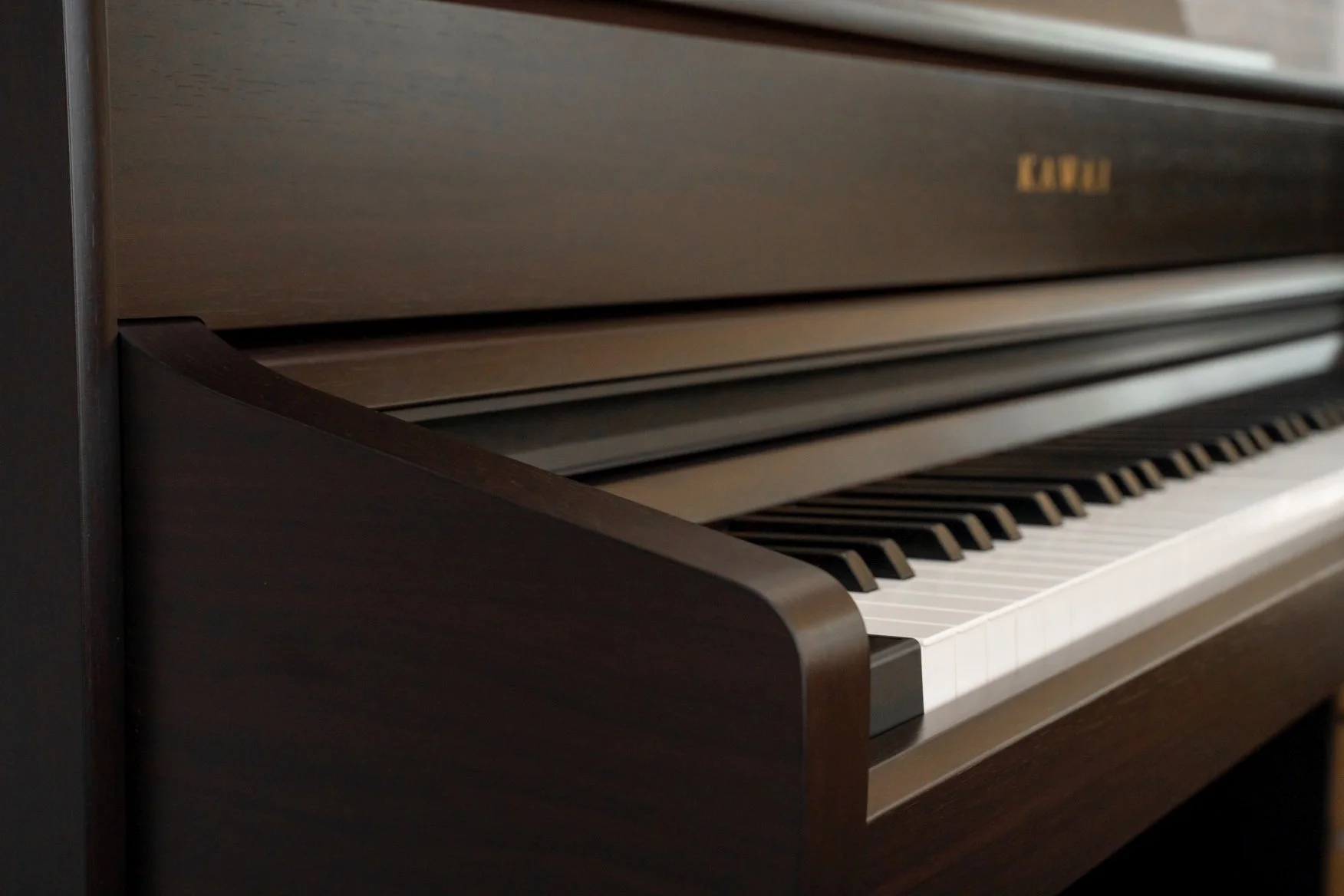 Kawai CA701 Digital Piano close up shot of side of cabinet and keys. 