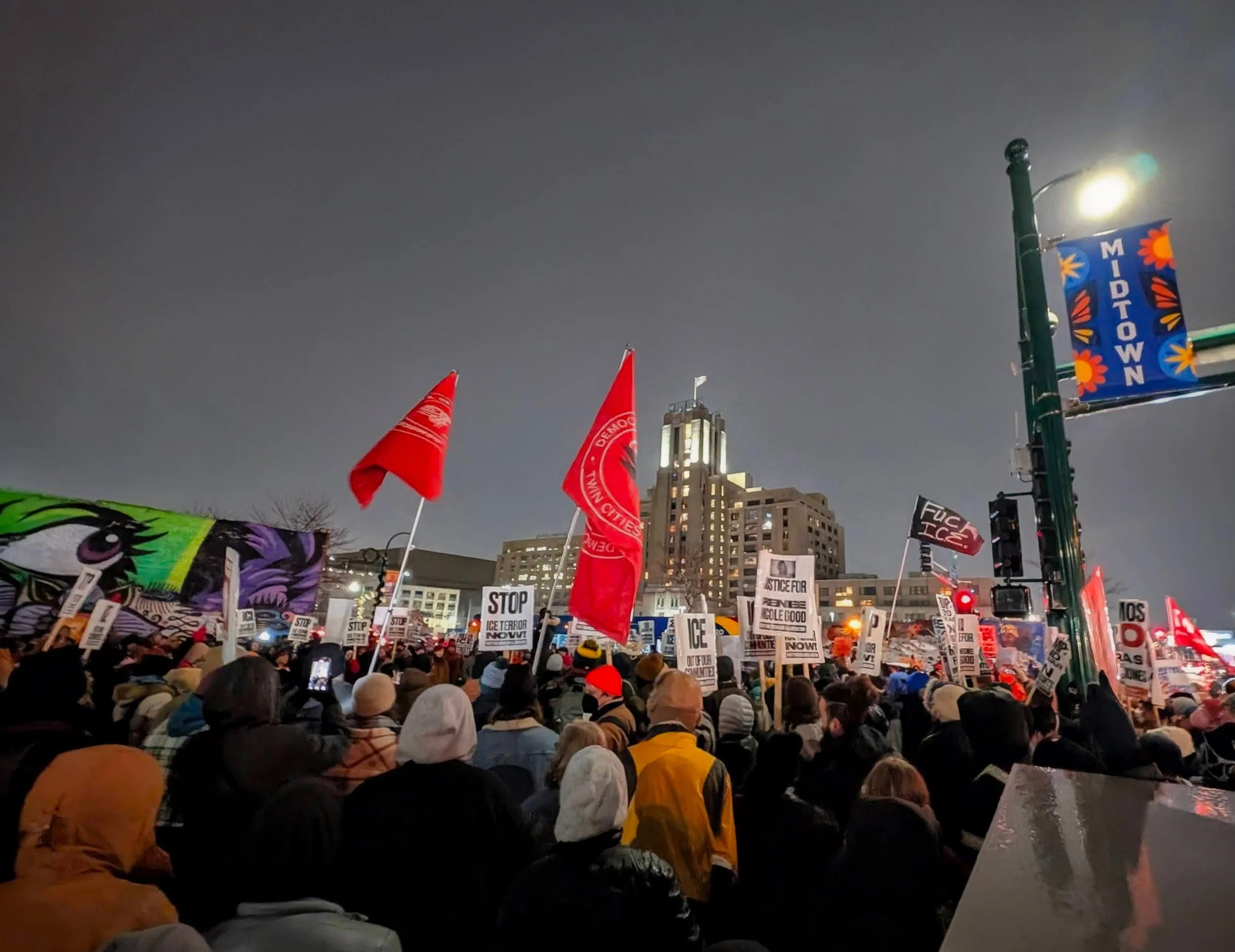 A large crowd of people with signs and flags, protesting in Minneapolis during the ICE attacks