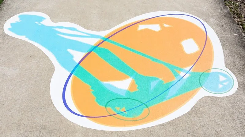 Colorful animated leaf design on concrete sidewalk with blue, orange, and teal shapes.