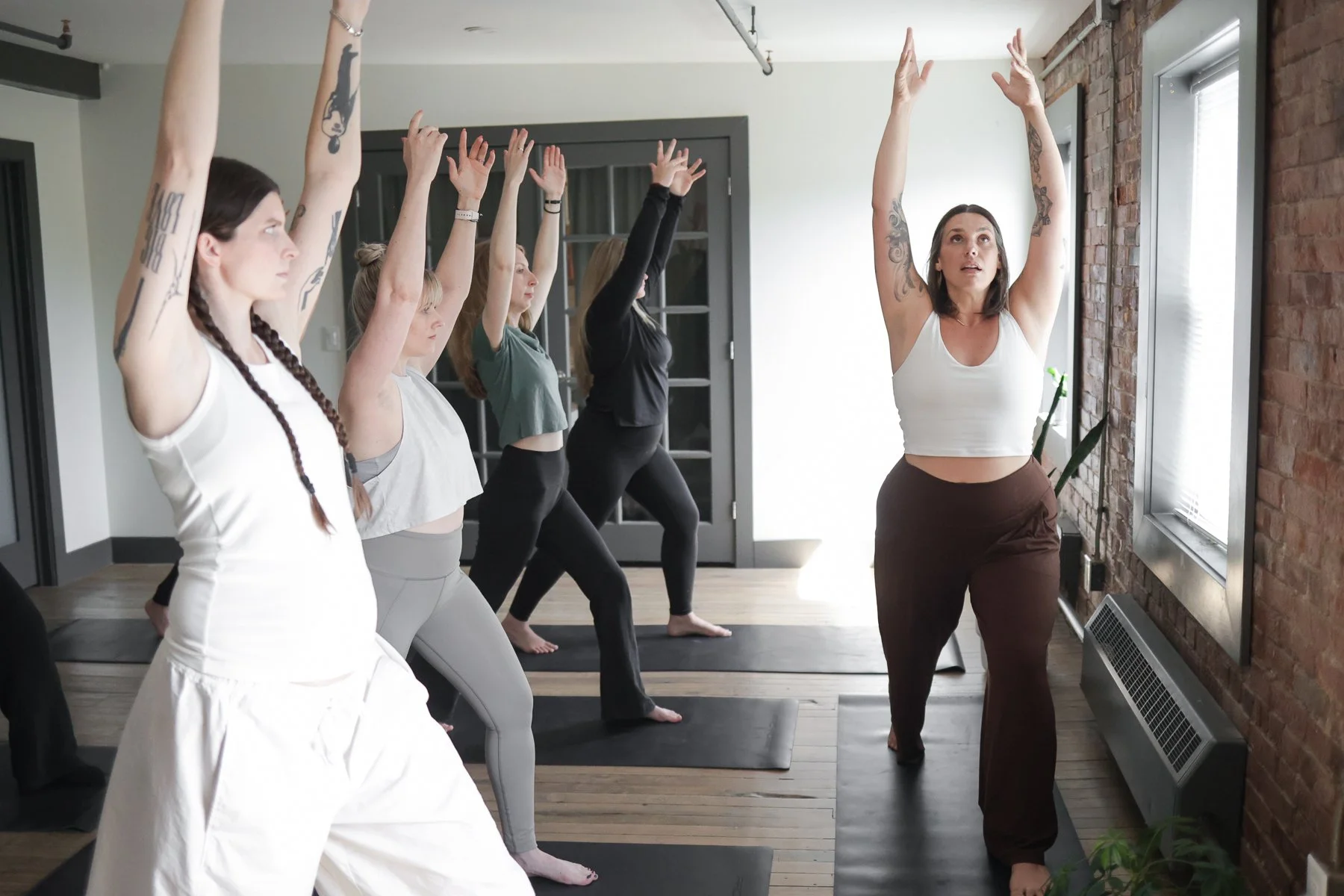 girl in white pants and white shirt doing a yoga pose
