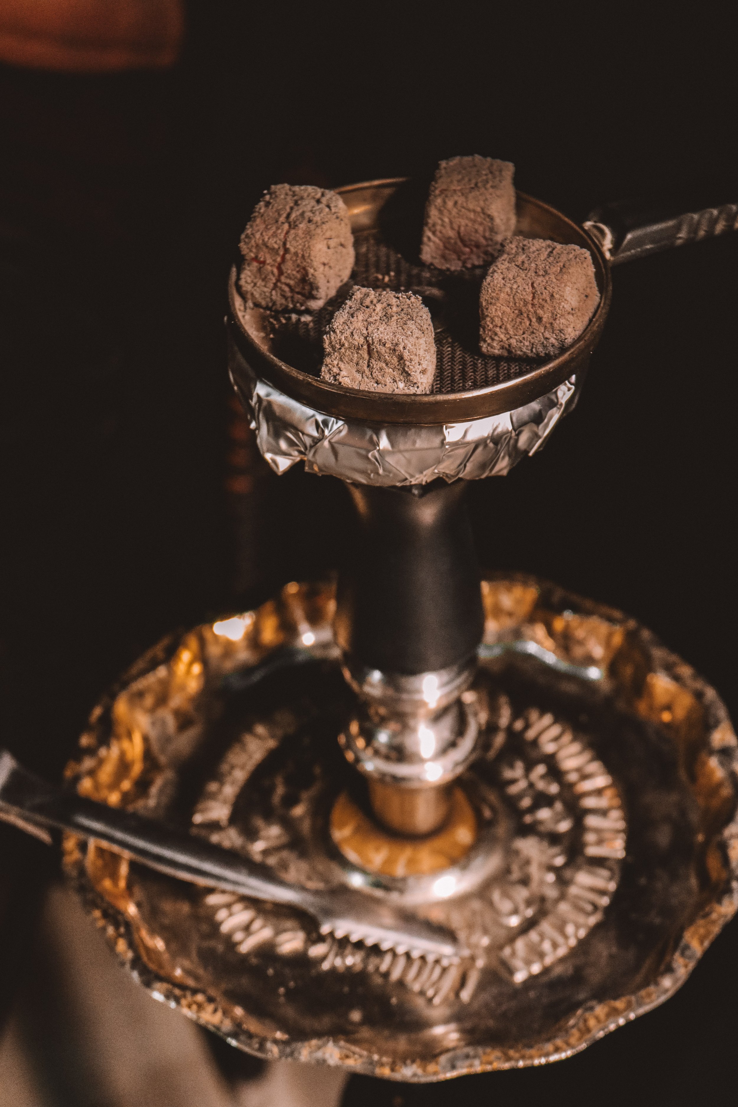 Coals in a traditional hookah bowl with foiled cover.