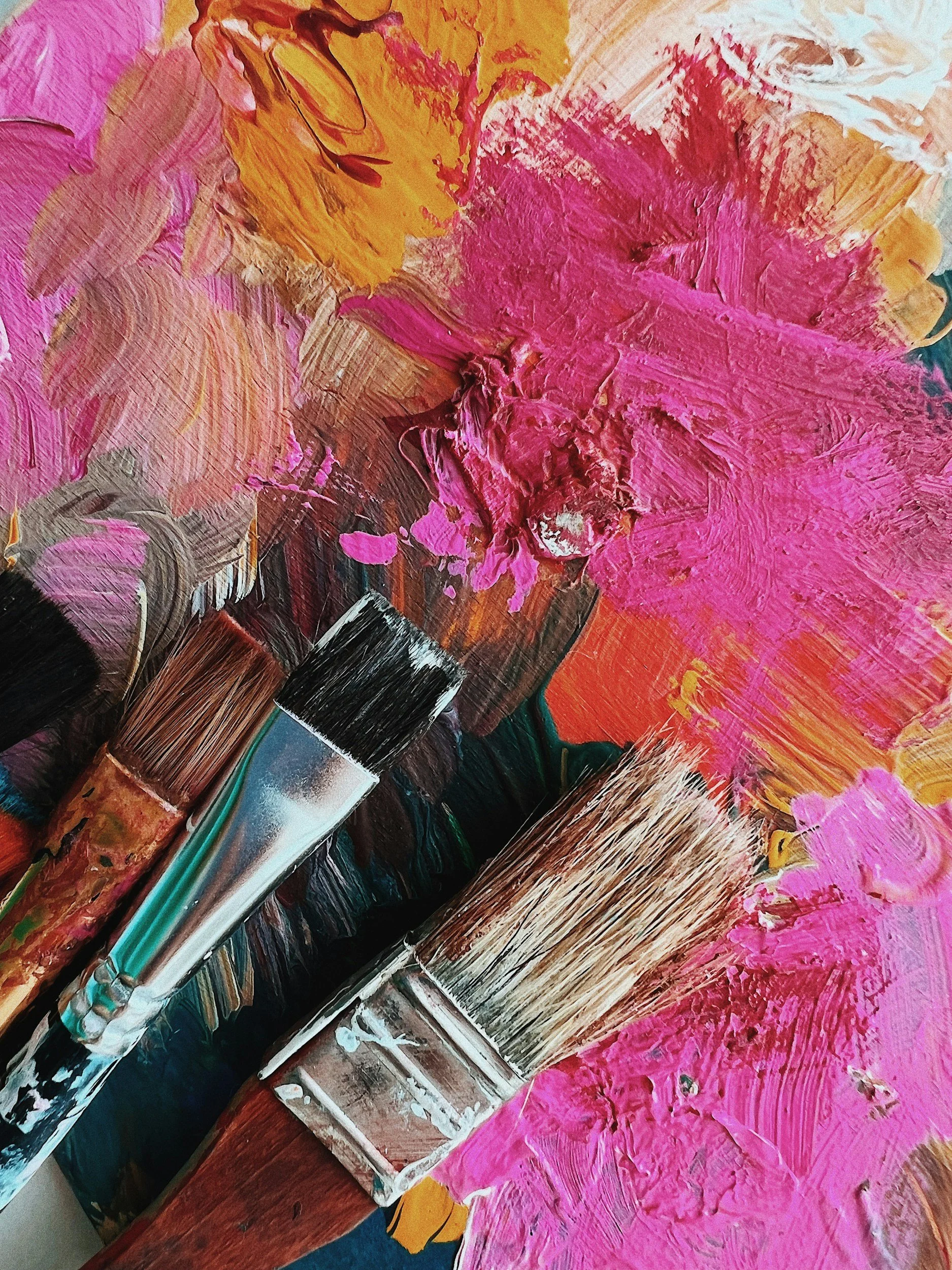 Creative Art Therapy NYC - Close-up of a textured abstract painting with pink, orange, yellow, black, and white brushstrokes.