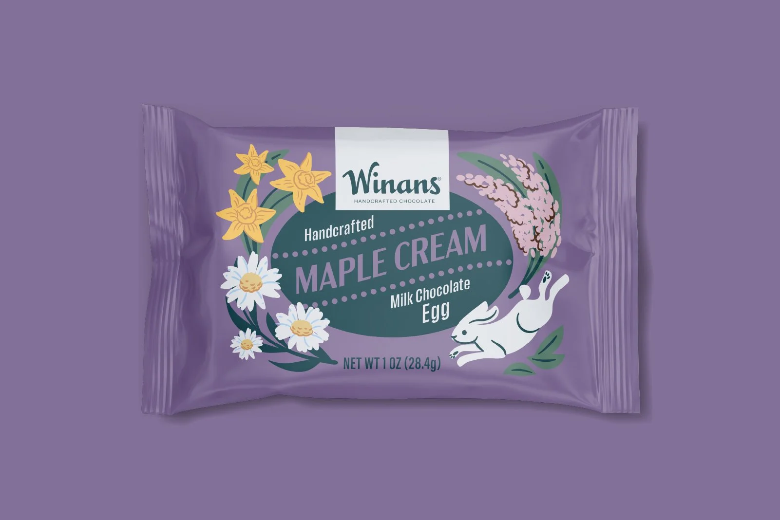 Purple packaging of Winans handcrafted maple cream milk chocolate egg with illustrations of daffodils, daisies, and a white rabbit on the front. Packaging design and illustration by Slagle Design. 