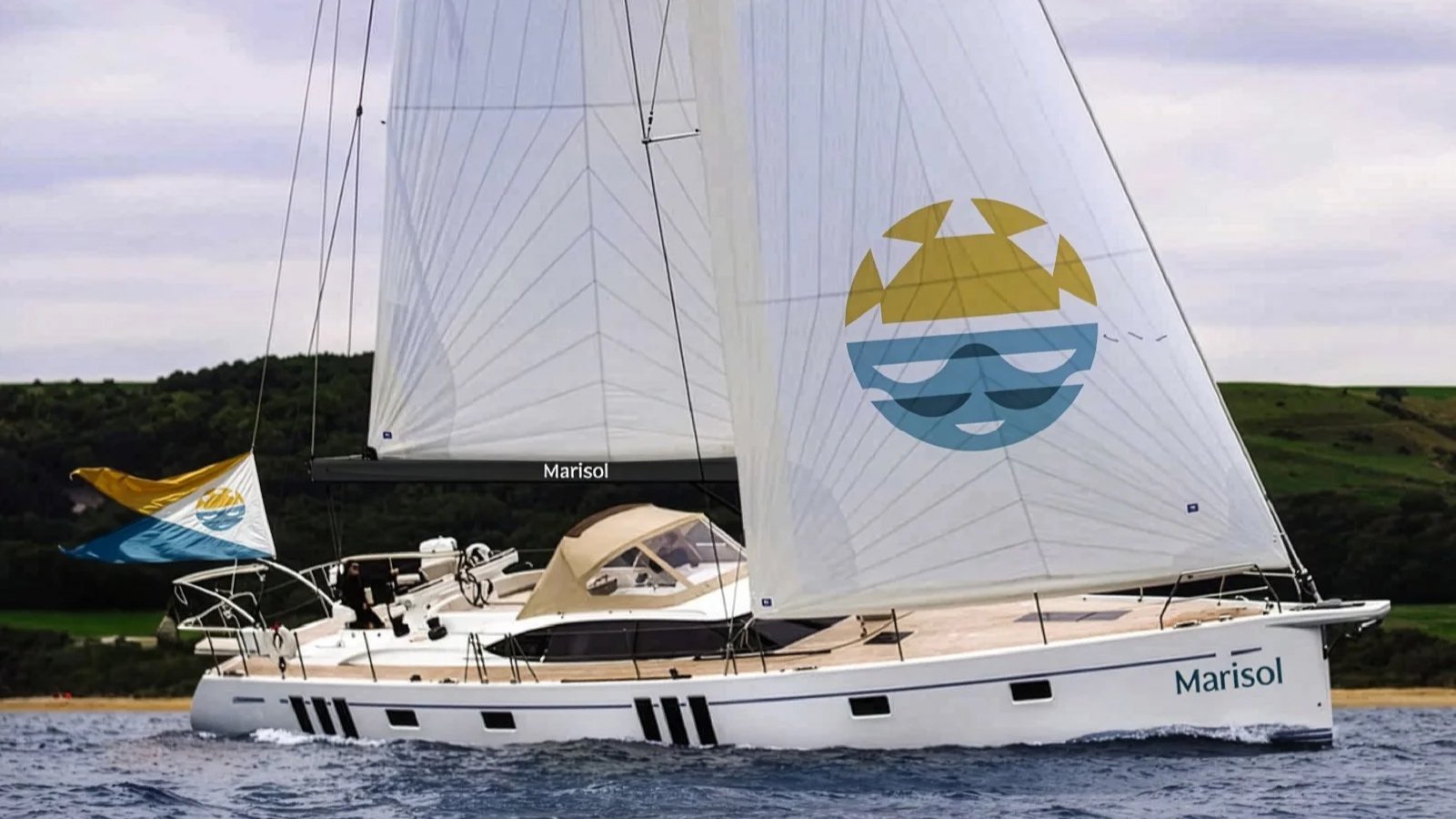 A sailboat named Marisol on the water with a landscape of green hills in the background. The sailboat has two sails, one large and one small, both featuring a logo of a smiling sun wearing sunglasses. The boat's deck includes controls and a beige canopy.