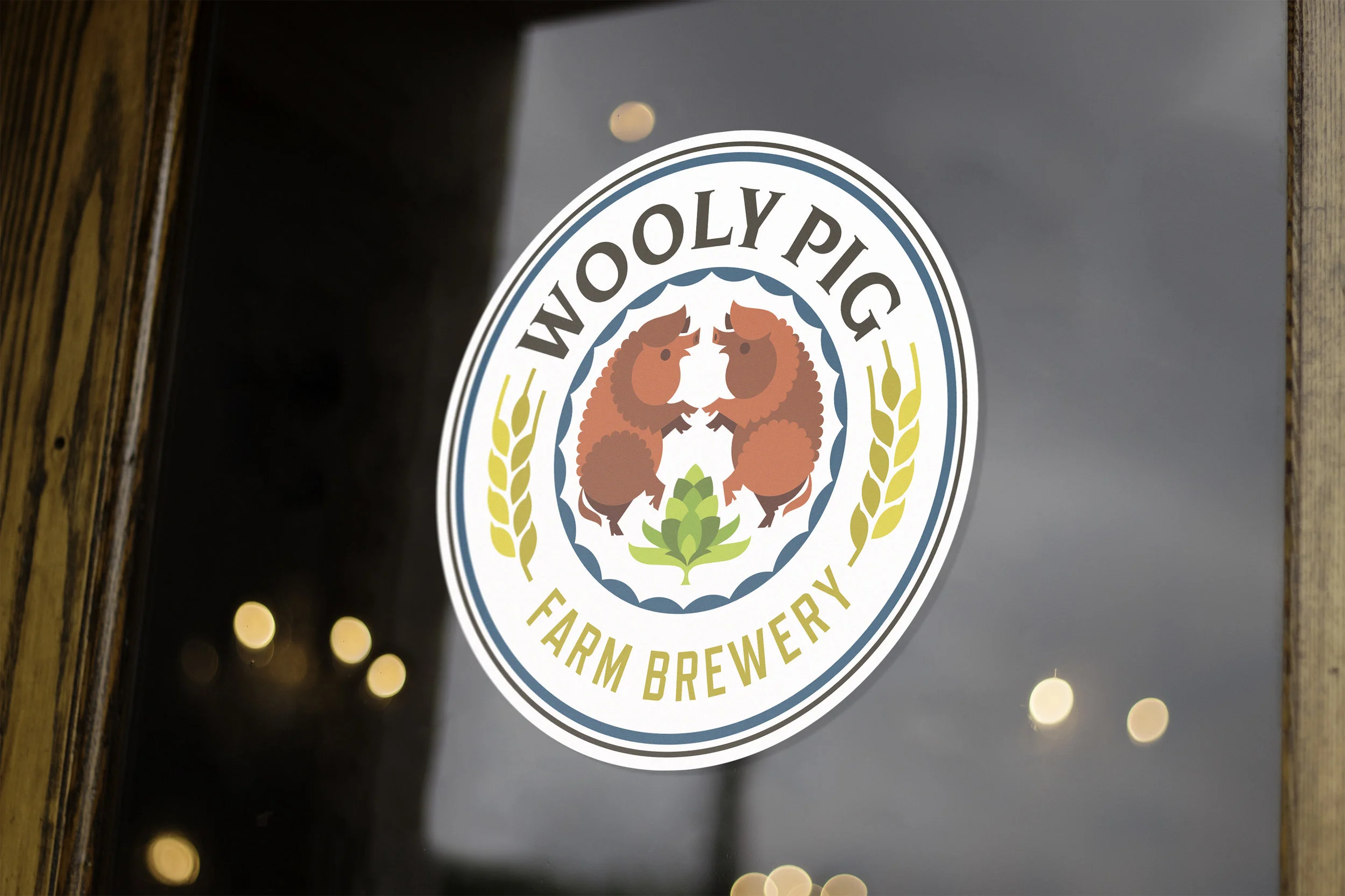 A logo on a glass door for Wooly Pig Farm Brewery featuring two cartoon pigs facing each other surrounded by wheat and hop illustrations.