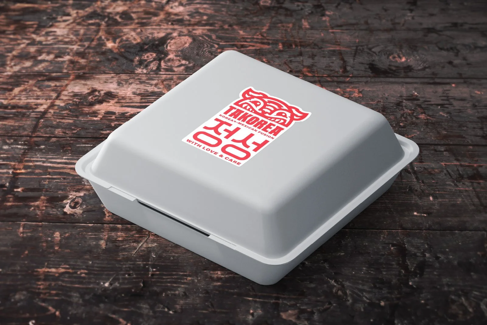 White takeout container with a red and white logo on the lid, placed on a dark wooden surface.