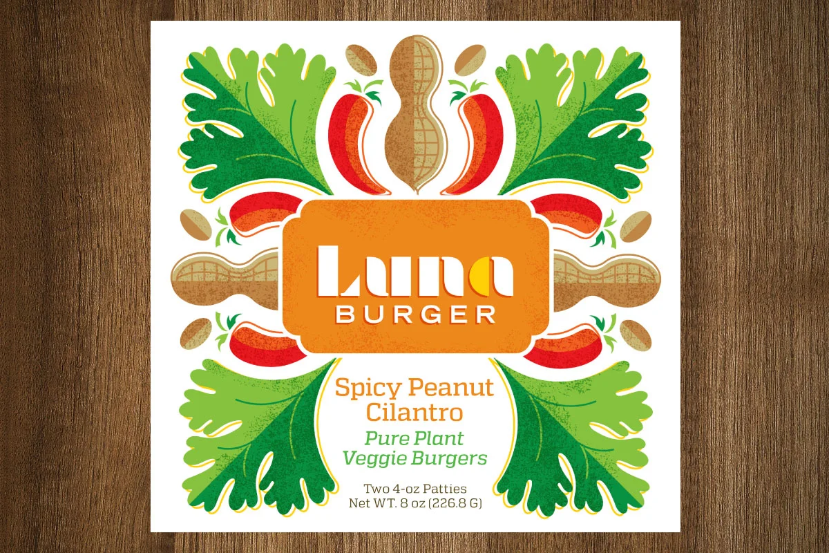 Label for 'Luna Burger' Spicy Peanut Cilantro veggie burger patties with illustrations of lettuce, peanuts, chili peppers, and peanuts on a white background with a wooden surface underneath.
