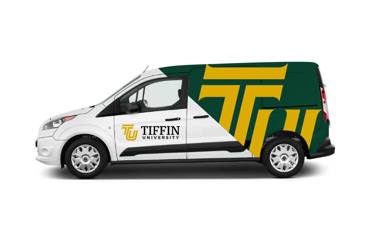 A white and green Tiffin University branded van with university logo and large green and yellow graphic design.
