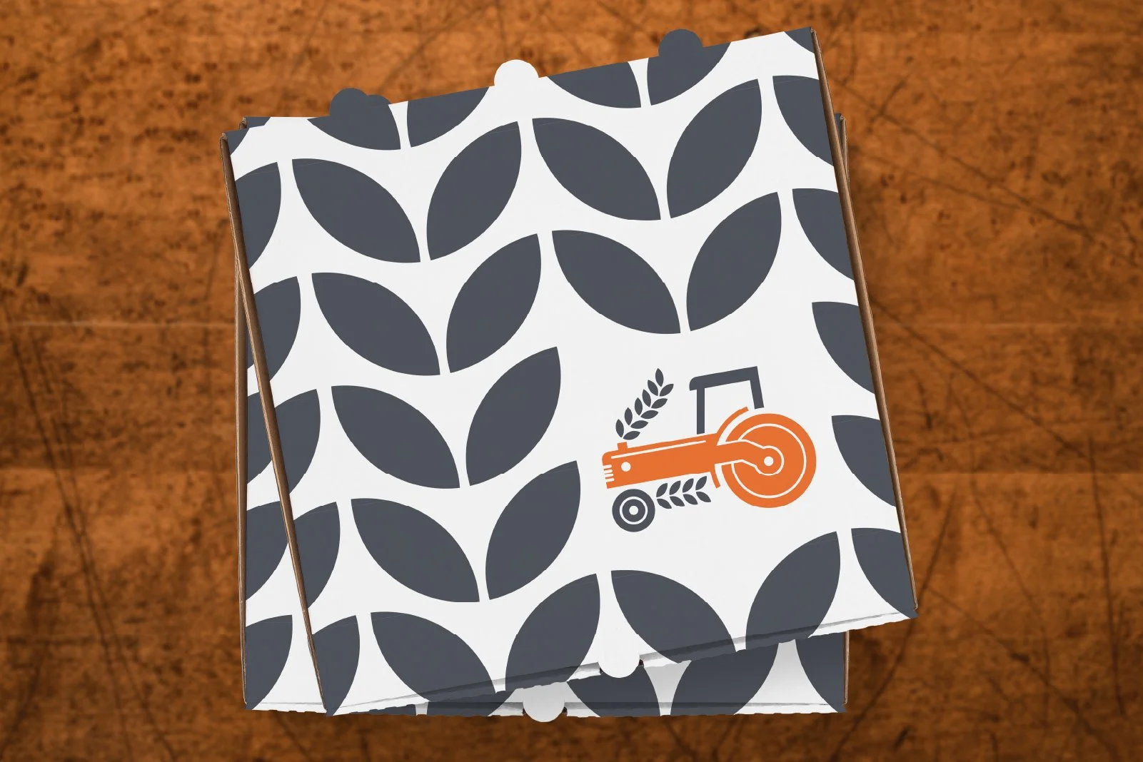 A patterned box with a tractor logo on top, placed on a wooden surface.