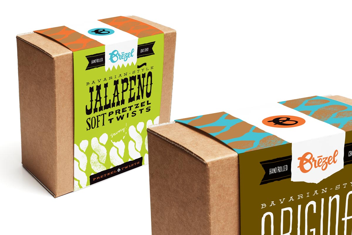 Two boxes of Bavarian-style jalapeno soft pretzels with hand-rolled twists, one with green and black labeling and the other with brown and blue labeling.