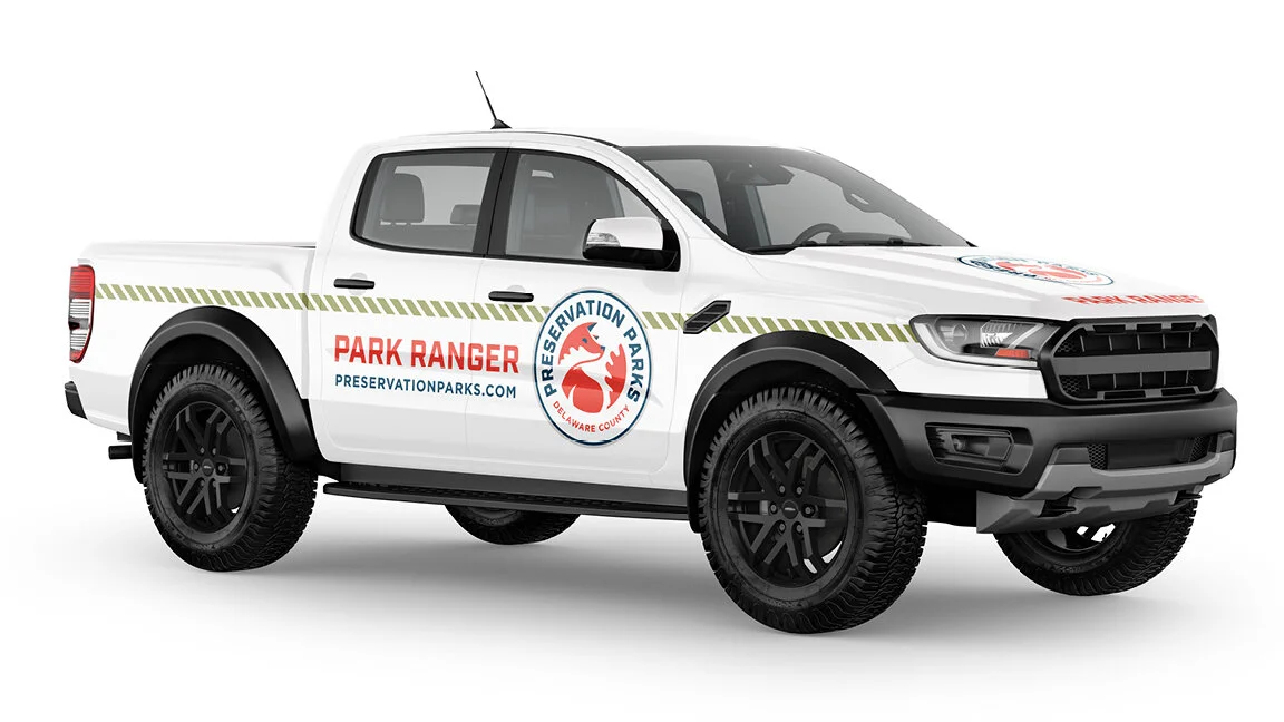 White pickup truck with 'Park Ranger' and 'Preservation Parks' logos, parked, with website preservationparks.com on the side.