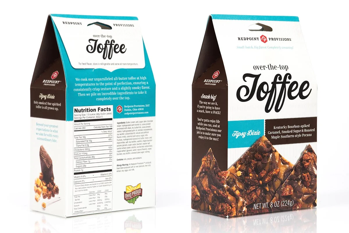 Two boxes of toffee candy, one showing the front and the other the back. The front label reads "Over-the-top Toffee" and describes it as Kentucky bourbon-spiked caramel, smoked sugar, roasted maple southern-style pecans. The back shows nutrition fact