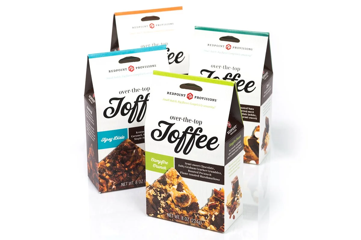 Four packages of Redpoint Provisions over-the-top Toffee in different flavors, placed on a white background.