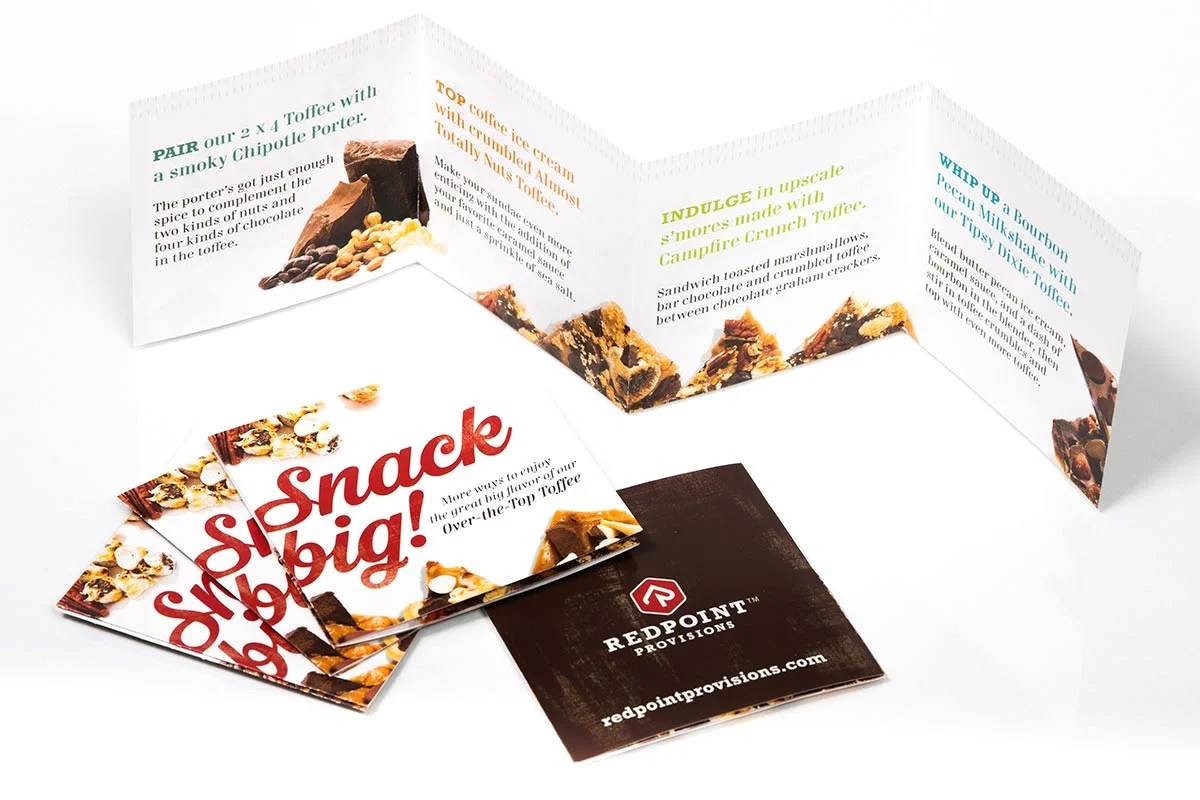 Folded promotional brochure for snacks with images of chocolate and nut treats, company logo for Red Point Provisions, and the slogan "Snack big!"