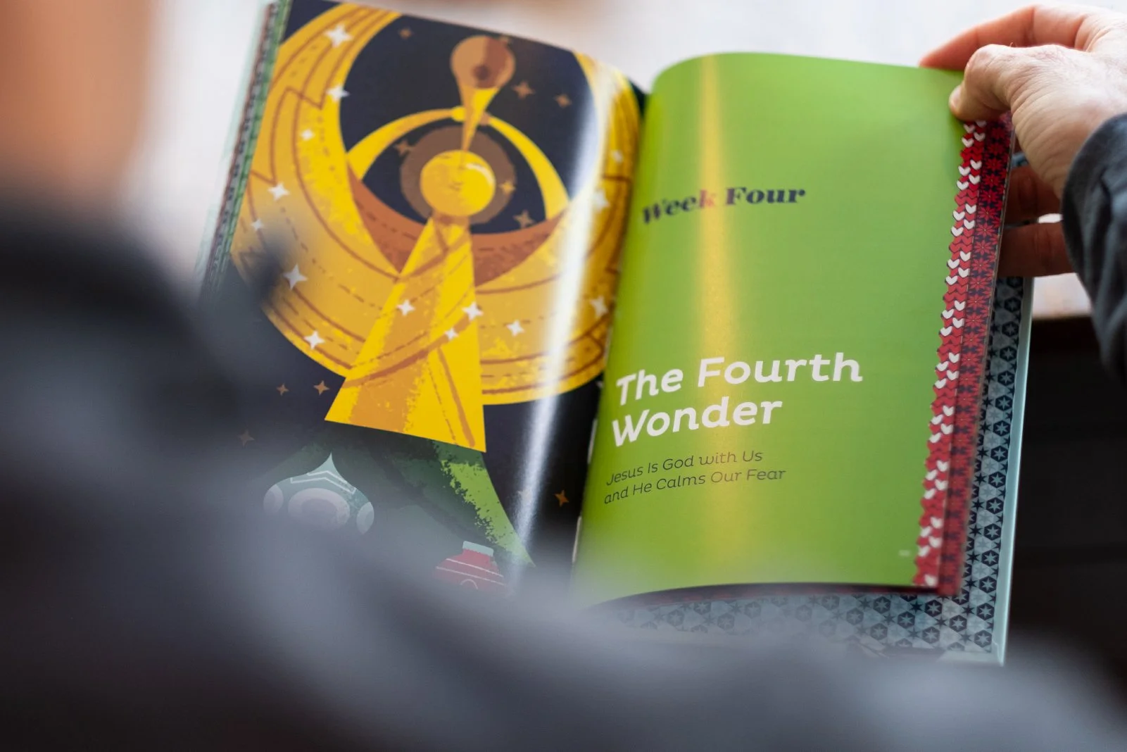 Open book with colorful illustrations and text about the fourth week of a religious or educational series, titled "The Fourth Wonder," with the subtitle "Jesus Is God with Us and He Calms Our Fear."