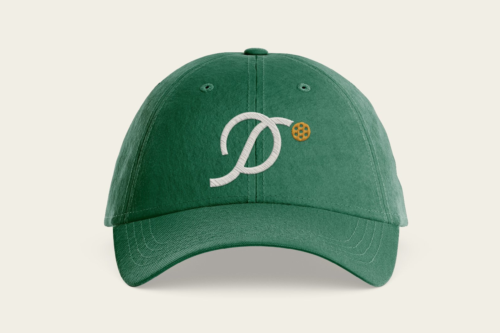 Green baseball cap with embroidered white monogram and small orange baseball on front.