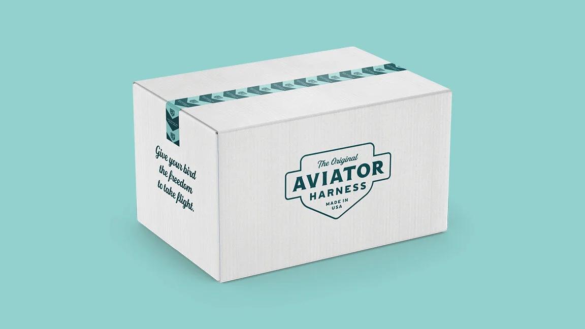 A white box labeled 'Aviator Harness' with a slogan 'Give your bird the freedom to take flight.' on a teal background.