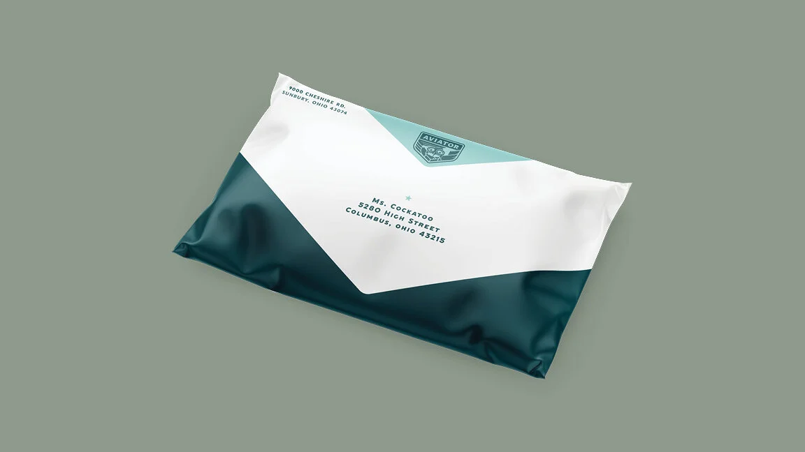 Envelope with a teal and white design and an aviation logo, addressed to Ms. Cockatoo in Columbus, Ohio.