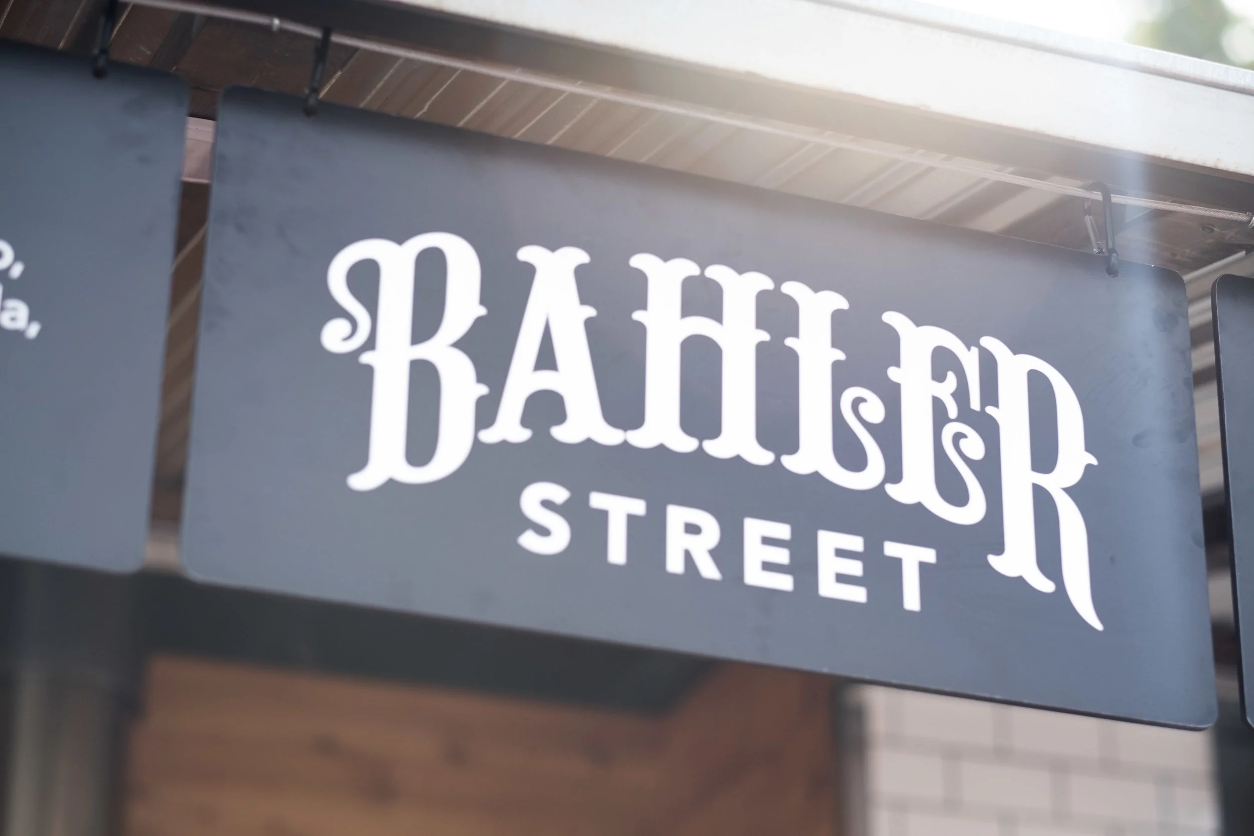 Sign for Bahler Street with stylized white lettering on a gray background.