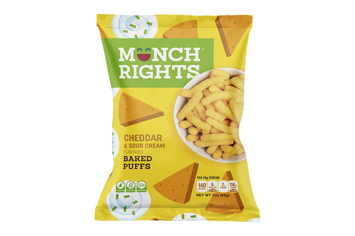 A bag of Monch Rights cheddar and sour cream flavored baked puffs with an image of cheese and puffs on the packaging. The bag is yellow with green and brown accents.