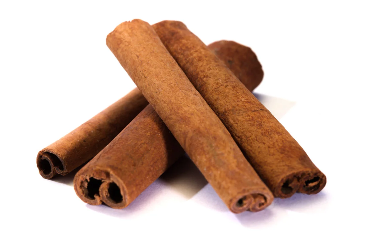 Four cinnamon sticks on a white background.