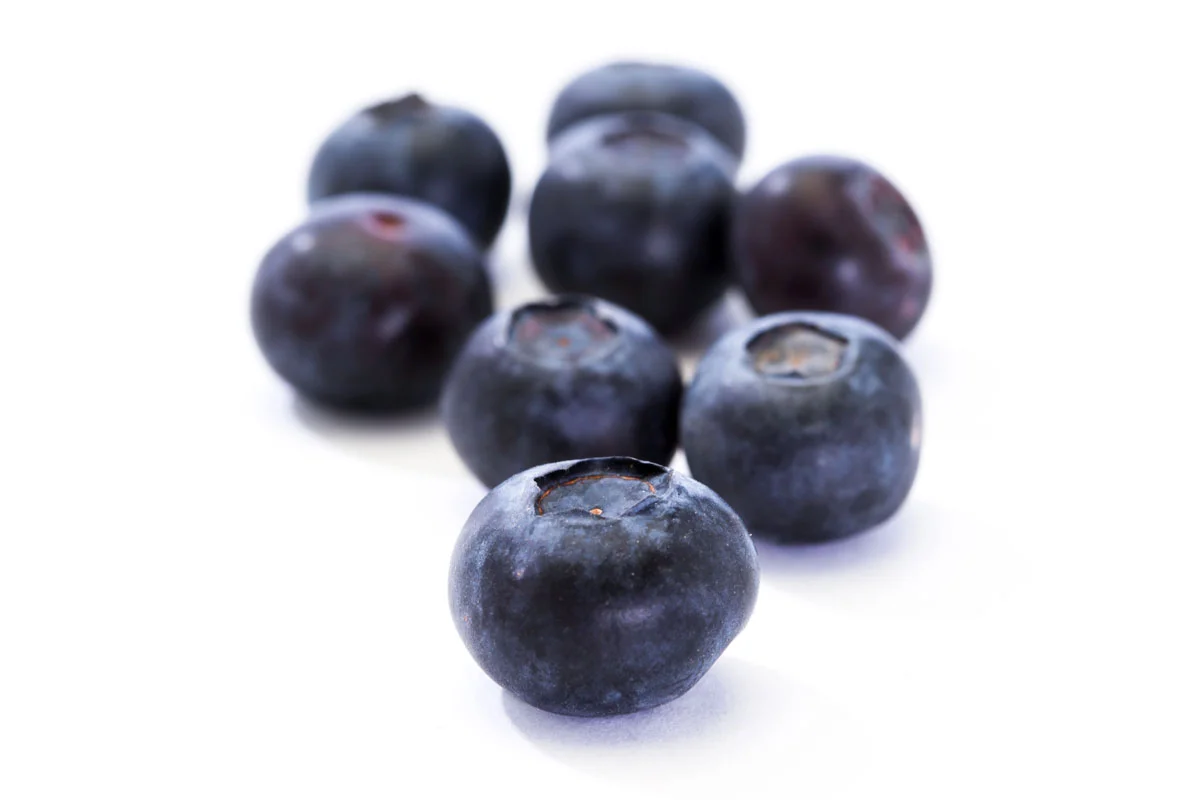 Fresh blueberries arranged on a white surface.