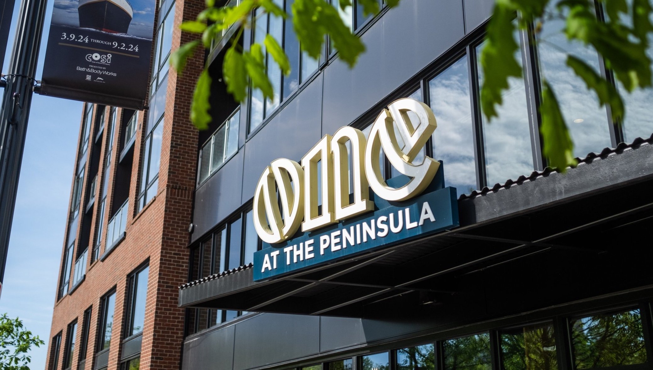 Sign for the Oce at the Peninsula restaurant on a building exterior.