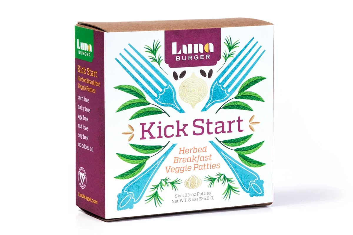 Front of a box of Luna Burger Kick Start Herbed Breakfast Veggie Patties, featuring a colorful design with green leaves, blue forks, and the product name.