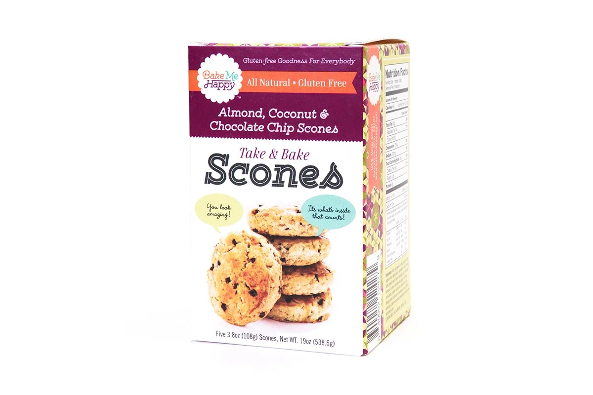 Box of Bake Me Happy Almond, Coconut & Chocolate Chip Scones, showing a stack of scones with a dialogue about how they look and what's inside.