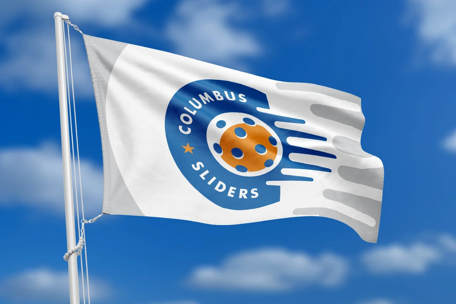 White flag with a circular logo featuring a stylized orange hockey puck with holes, surrounded by a blue ring with the words 'Columbus Sliders' and a small yellow star, flying against a blue sky with clouds.