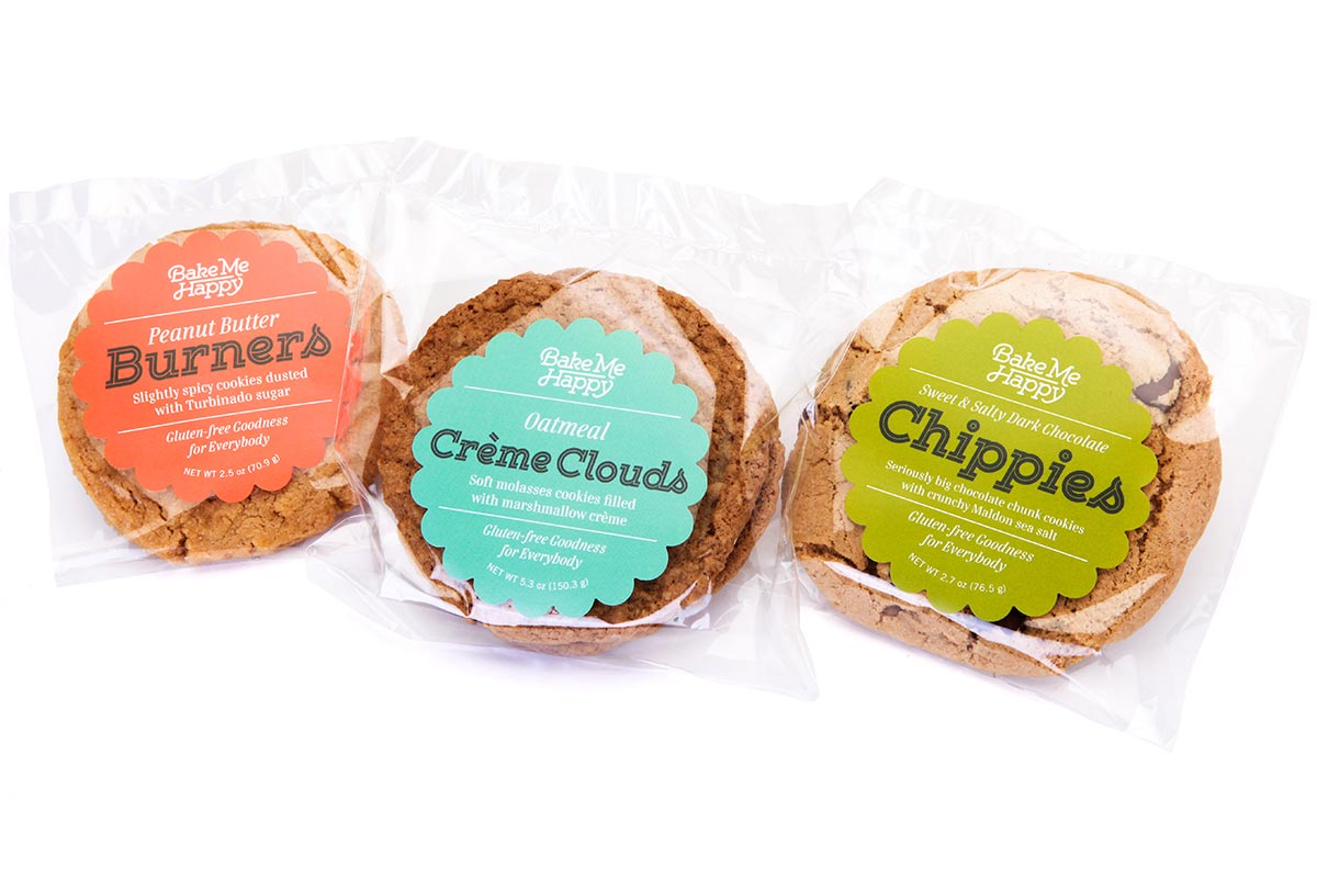 Three packs of cookies in clear plastic wrapping with colorful labels. From left to right: Peanut Butter Burners, Oatmeal Crème Clouds, and Chippies.