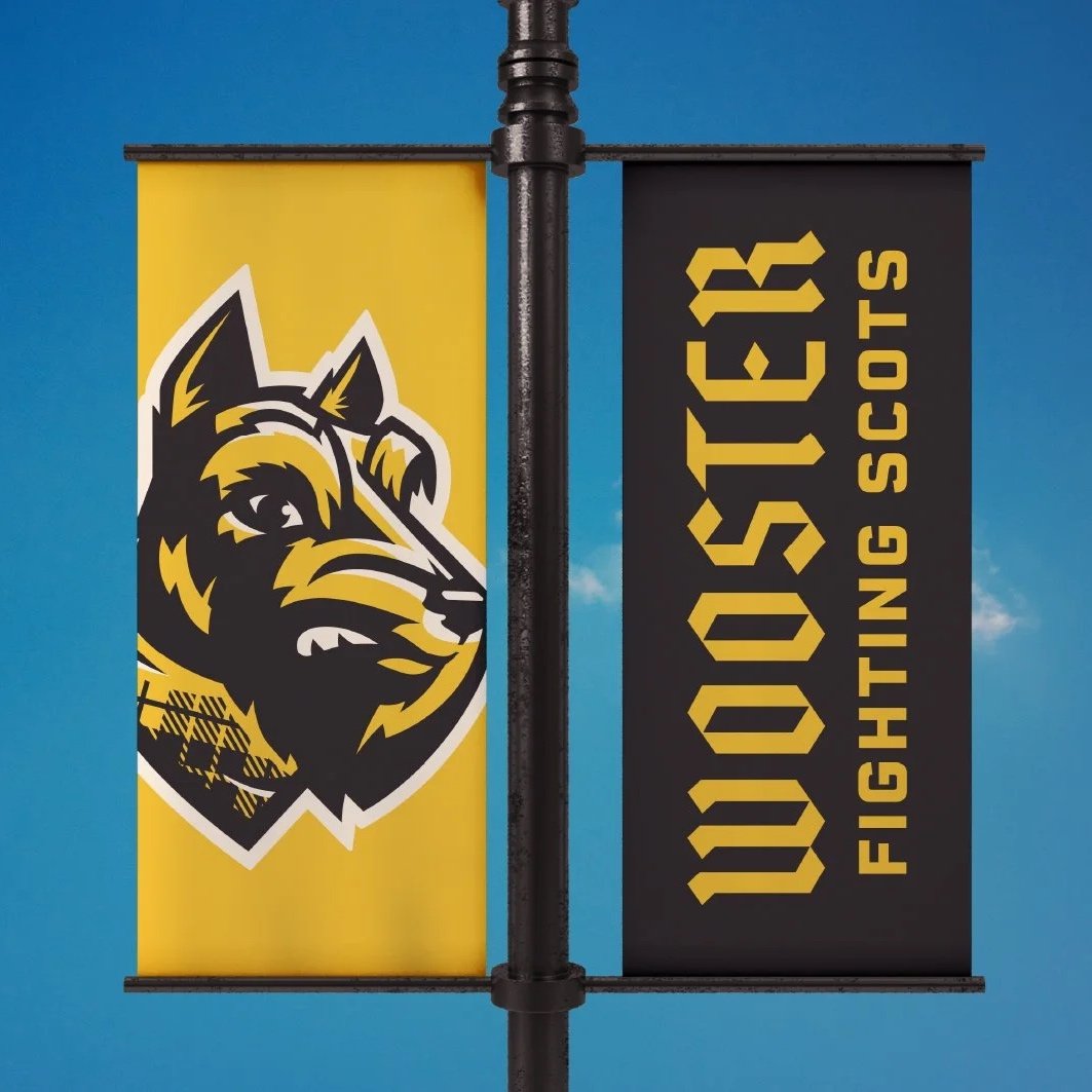 Two banners on a pole, one yellow with a wolf logo, the other black with yellow text reading 'WOUSTON SCOTS FIGHTING SCOTS'.