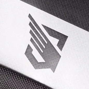 Close-up of a white surface with a stylized black geometric logo.