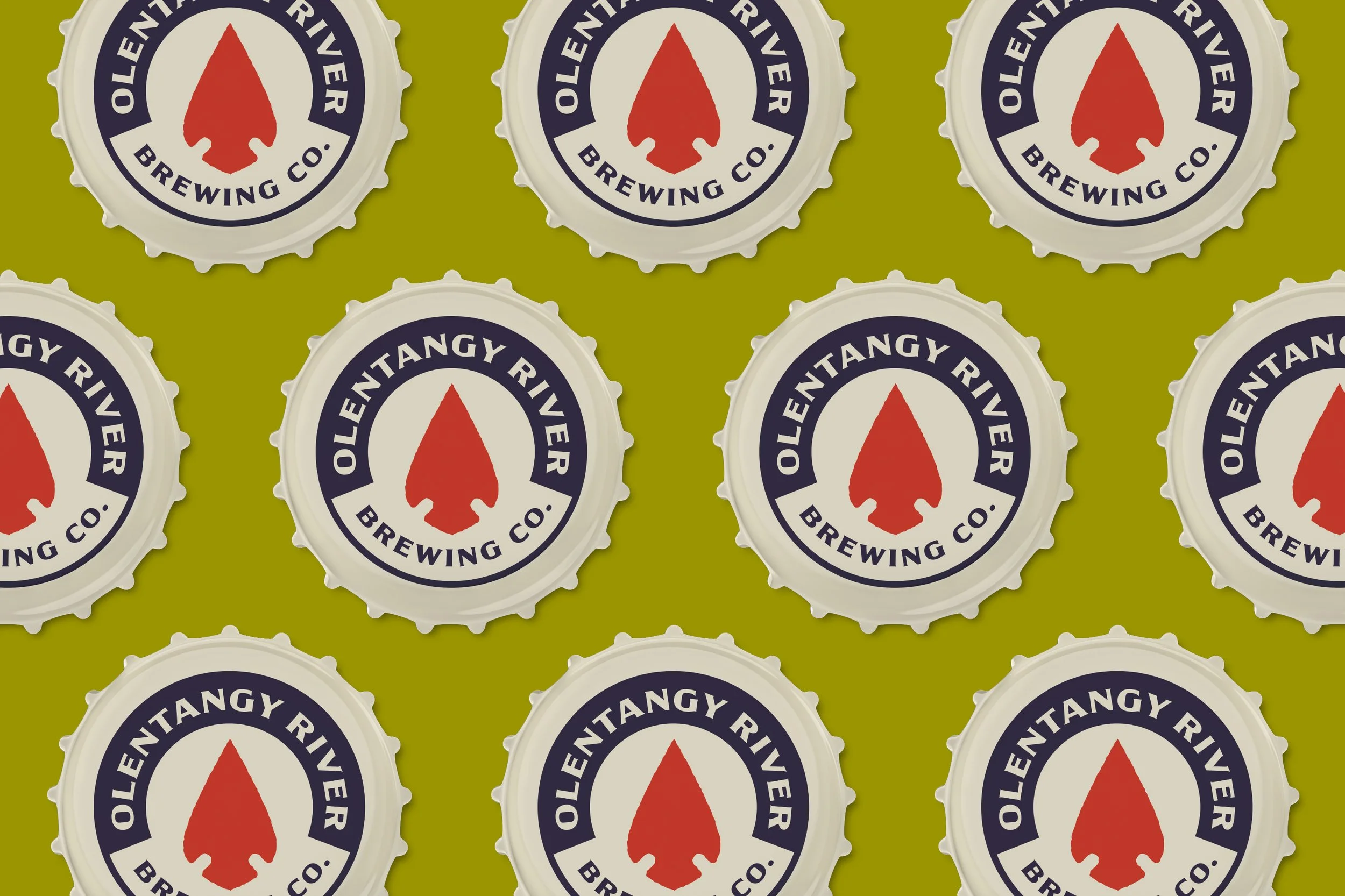 Multiple bottle caps with the logo of Oltentangy River Brewing Co., featuring a red arrowhead and the company name on a green background.
