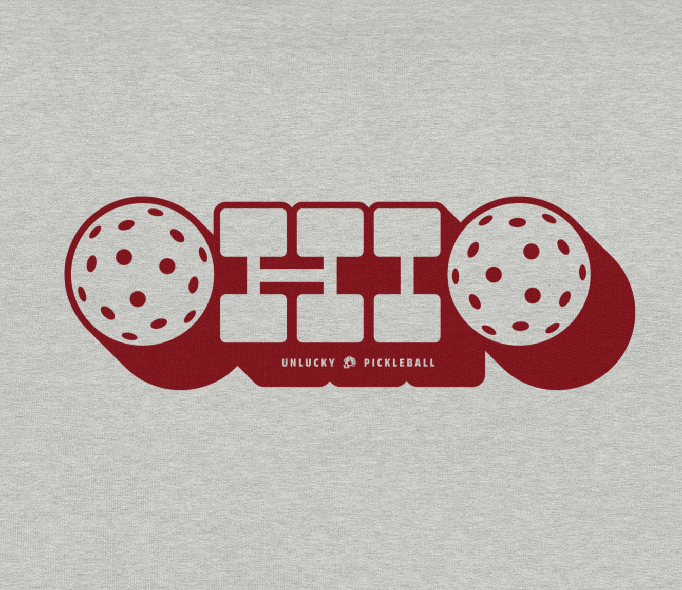 Graphic design of two pickleball paddles with pickleball balls, with the text "Unlucky Pickleball" underneath.