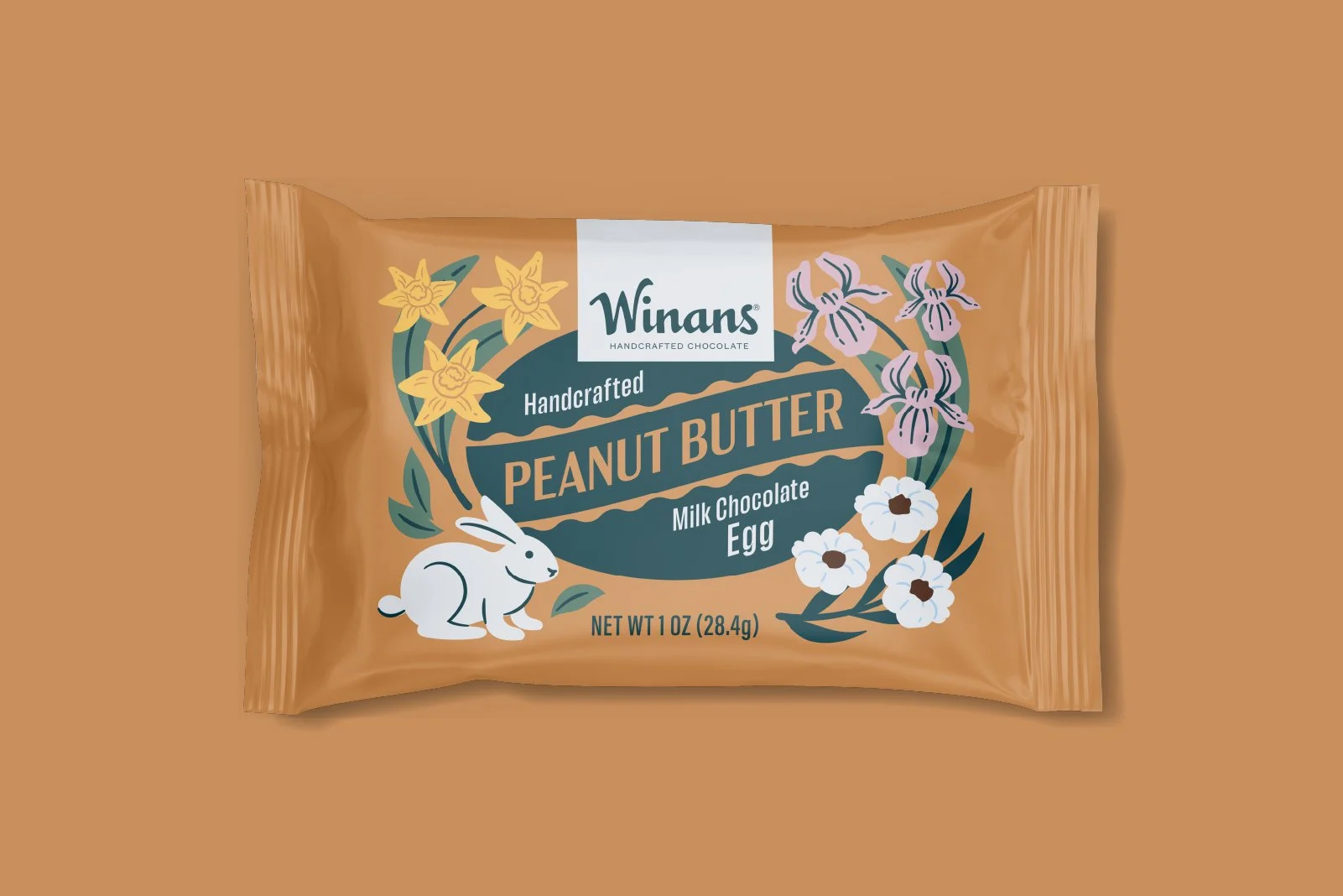 Packaged Winans handcrafted peanut butter milk chocolate egg with floral and bunny illustrations on a brown background. Packaging design and illustration by Slagle Design. 