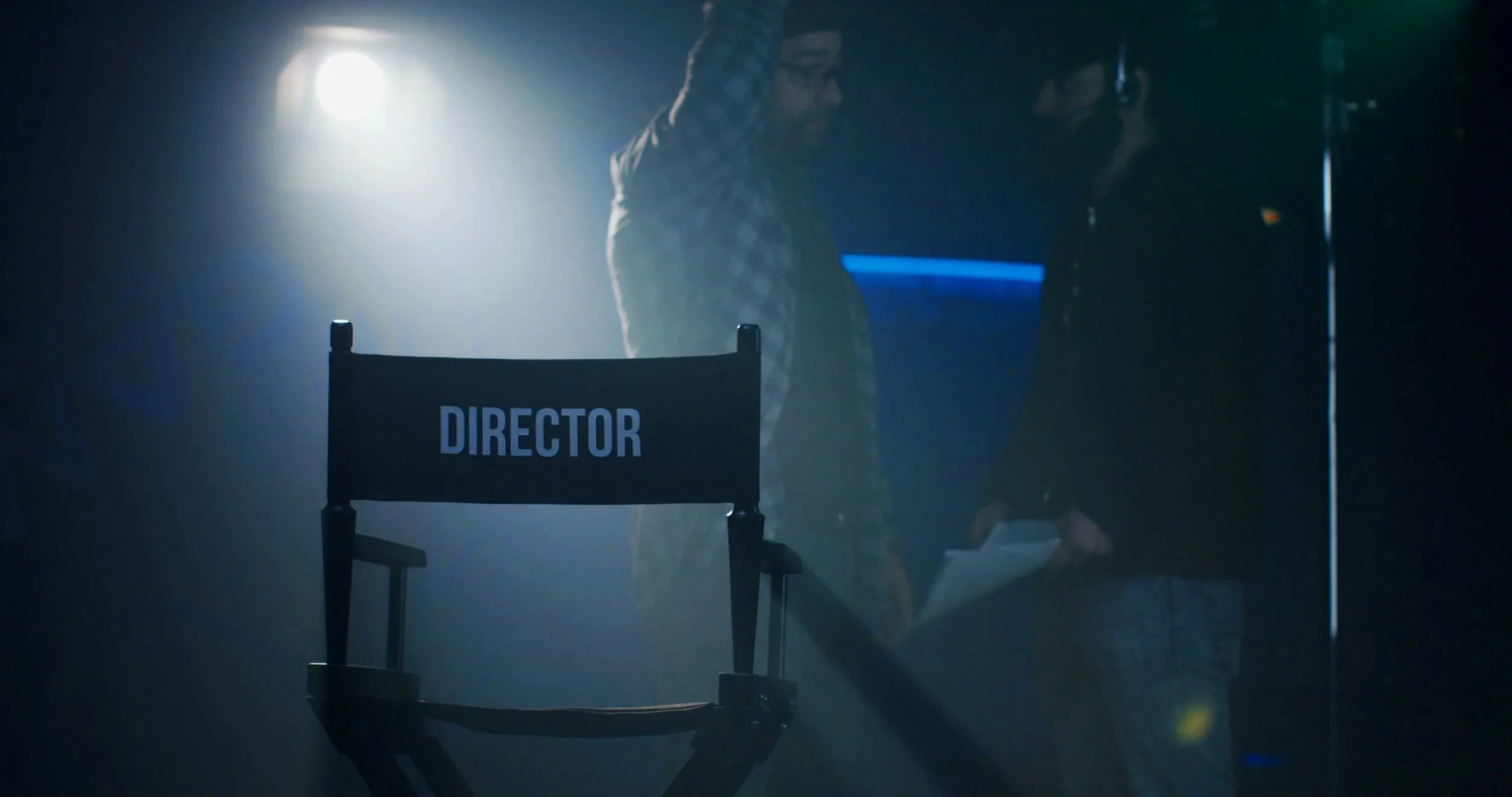 two-men-standing-in-spotlight-on-movie-set-and-arguing-for-position-of-film-director-SBI-351366218.jpg
