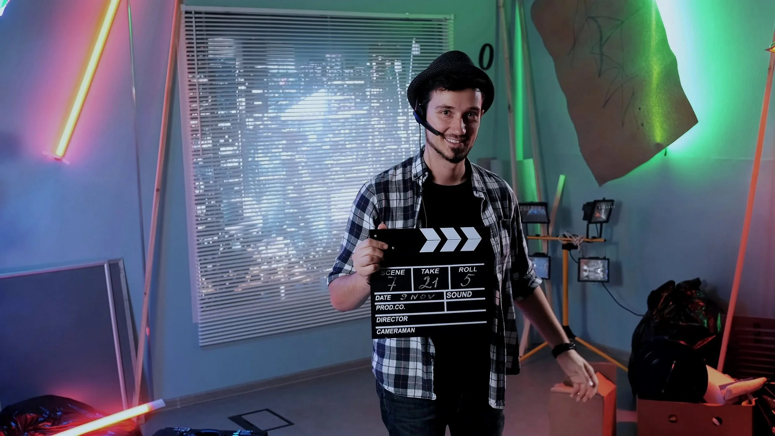 portrait-of-producer-assistant-smiling-to-the-camera-and-giving-action-with-movie-clap-SBI-350199251.jpg