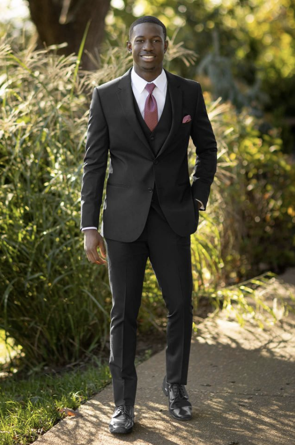 Man standing outside wearing a black suit