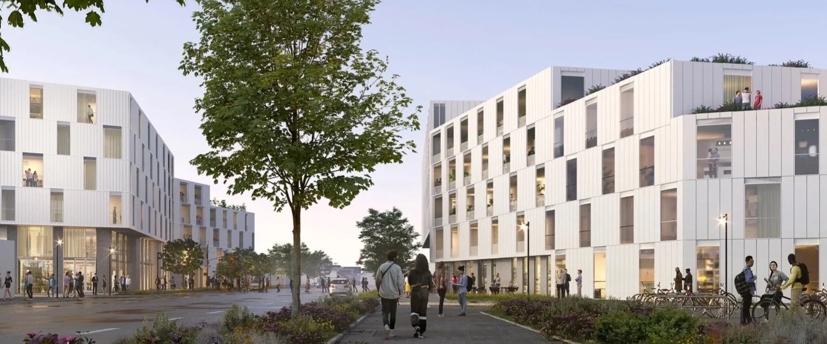 Modern white multi-story apartment buildings with people walking and socializing outside on a paved walkway, surrounded by trees and greenery in an urban setting.