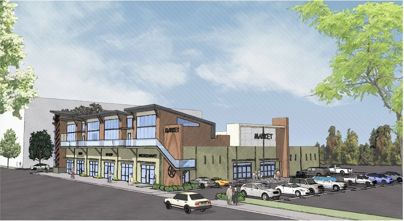 A modern shopping mall with multiple storefronts, parking lot, and a landscaped area with trees.