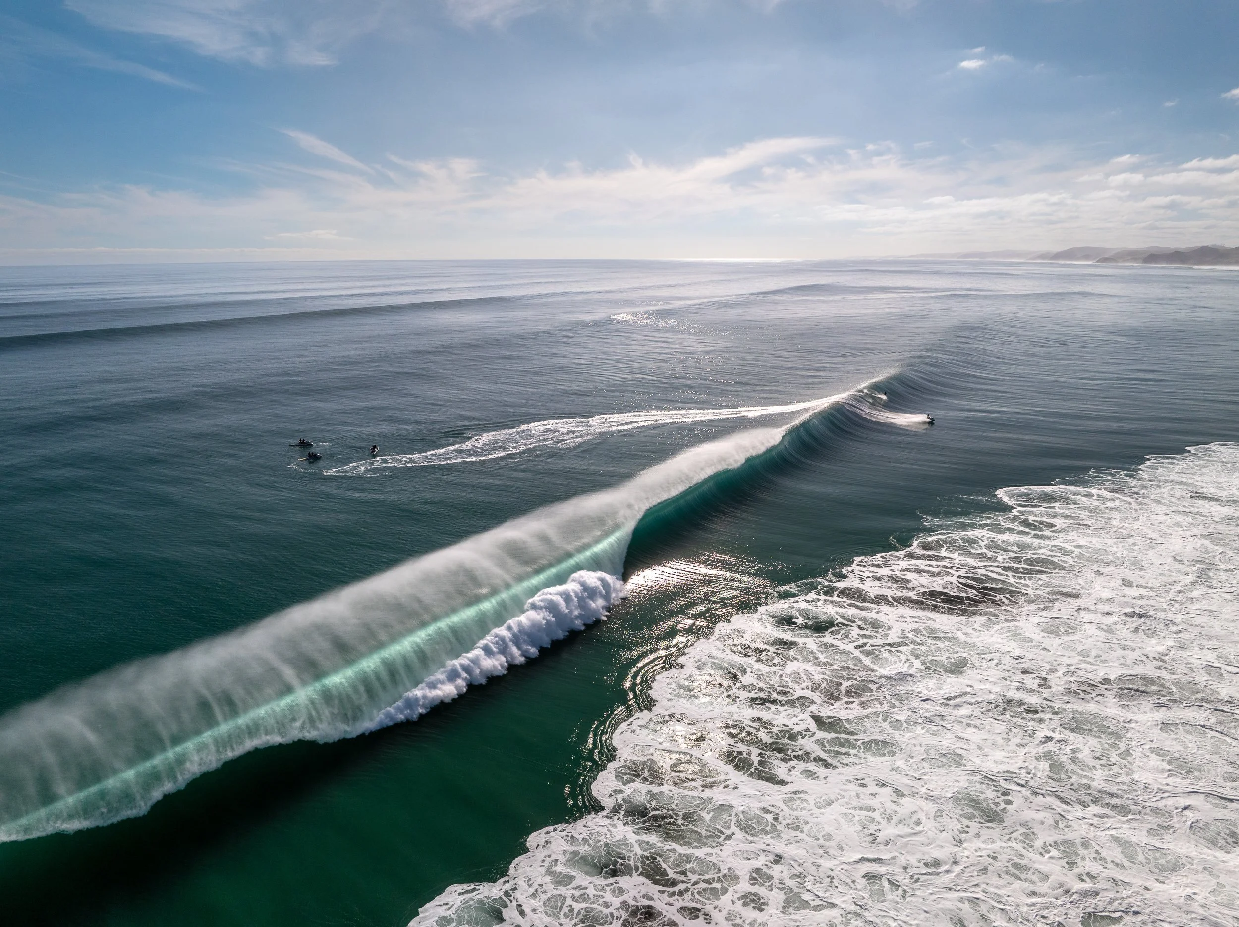A rare window of flawless conditions on the Raglan coast. This shot captures a massive, glassy swell marching forward under perfect light offshore winds—a day where the water turned a deep, crystalline blue and the spray trailed off the peaks like si