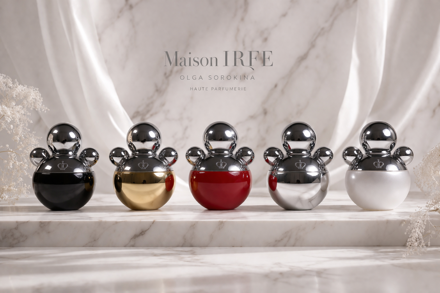 Five designer perfume bottles with rounded shapes and crown logos on the front, arranged in a row on a marble surface with a white and beige marble backdrop, displaying various metallic finishes including black, gold, red, silver, and white.