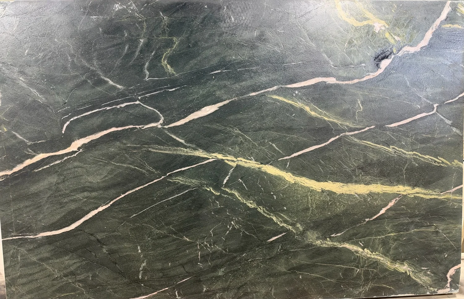 Deep green stone with pale pink and gold veining