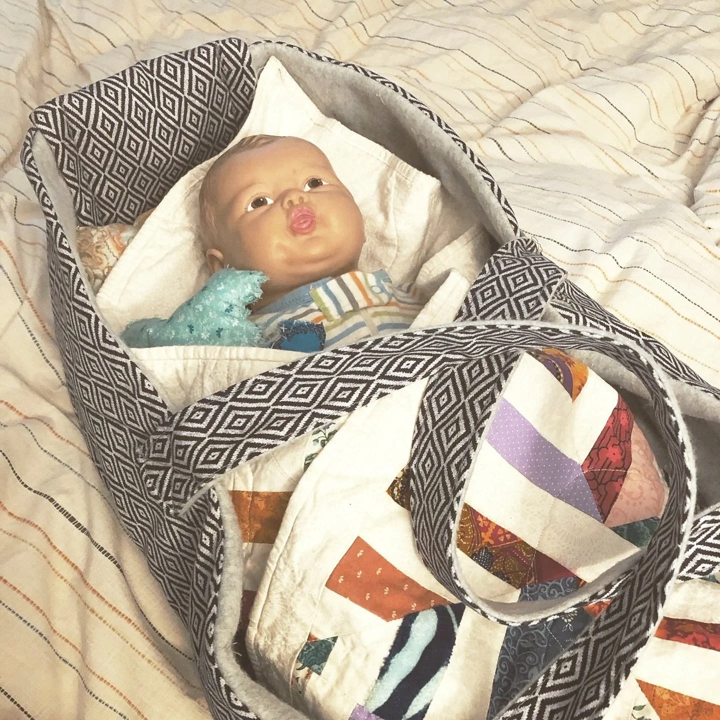 This baby doll was given to my grandmother on her fifth birthday. She lent it to me when I was small, and I lent it to my youngest in turn. Baby (as she is known) is wrapped in a blanket and a Moses basket I made. 