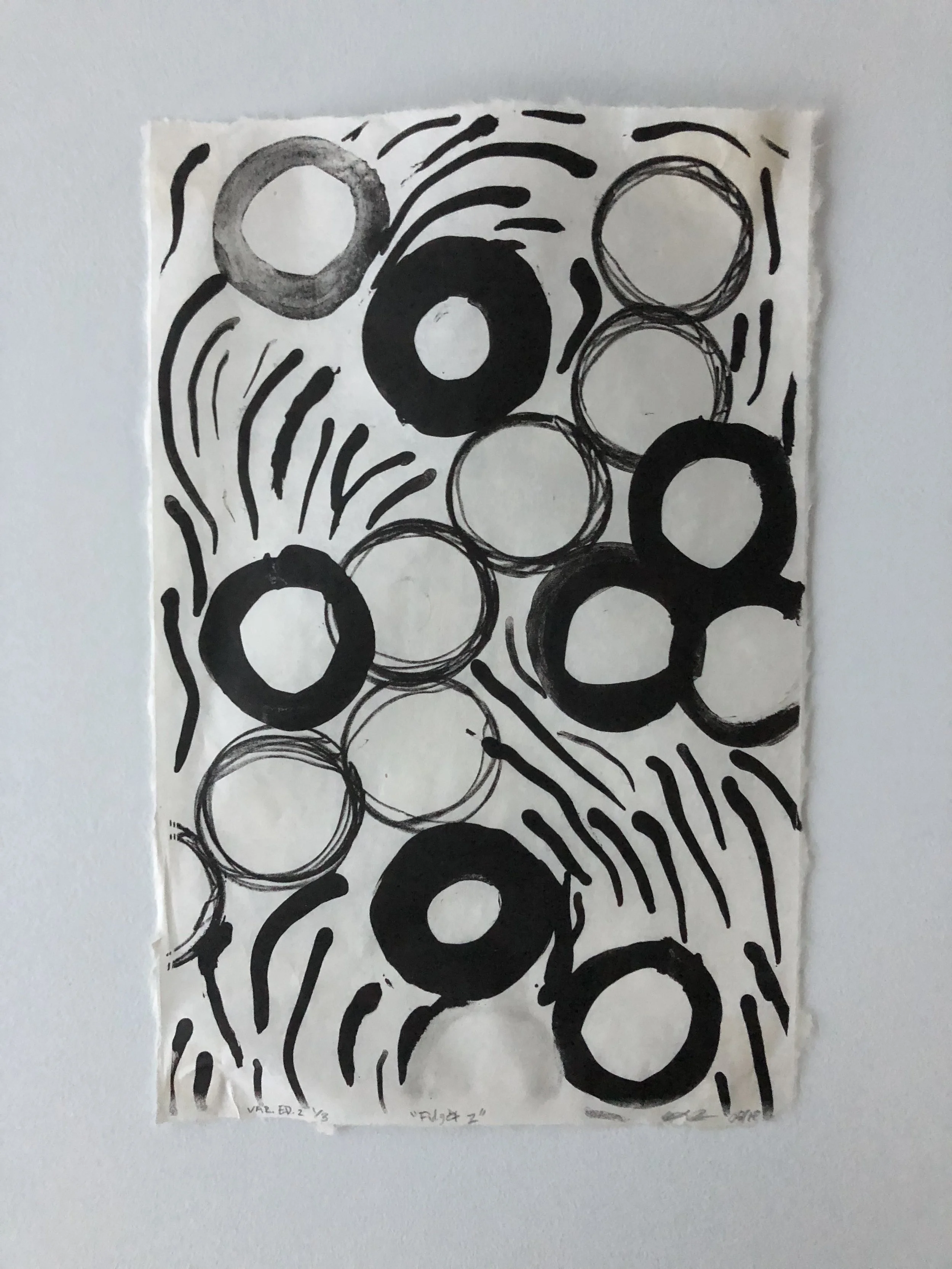 Abstract black and white artwork with circles and wavy lines on paper taped to a wall.