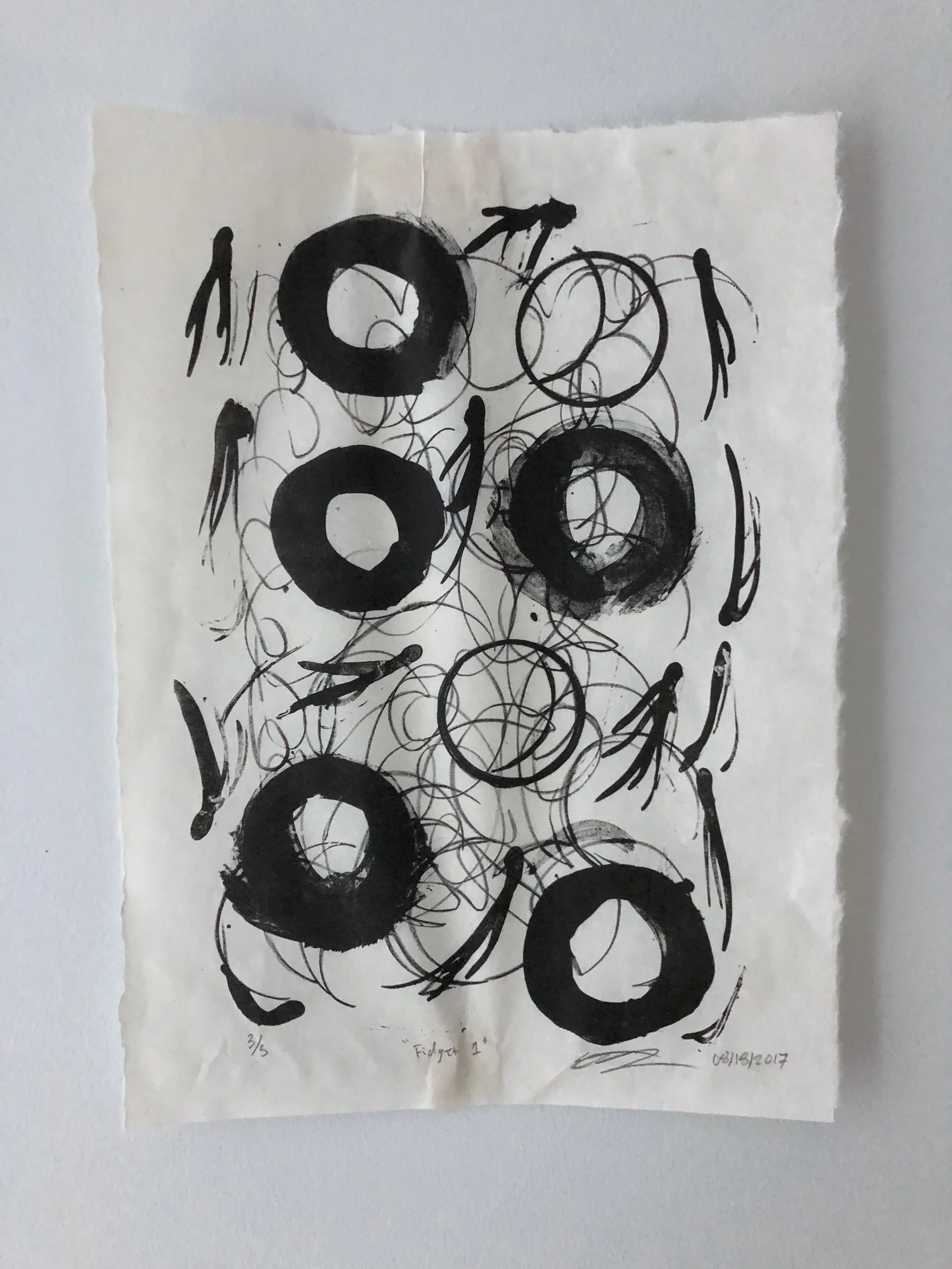 Abstract black and white drawing with large circular shapes and scribbles on a textured paper background, signed and dated.